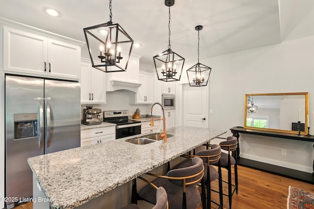131 Gavin Dr, Shepherdsville, KY 40165 - kitchen with stainless steel appliances, a chandelier, dark wood finished floors, a kitchen island with sink, and white cabinetry