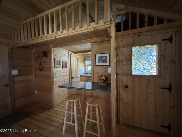 661 Blue Bird Rd, Falls Of Rough, KY 40119 - kitchen with wood walls, lofted ceiling, hardwood / wood-style flooring, a breakfast bar, and dark countertops
