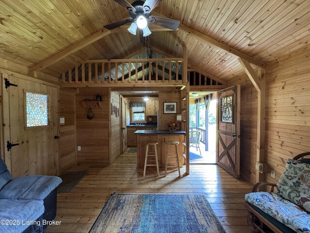 661 Blue Bird Rd, Falls Of Rough, KY 40119 - kitchen featuring wooden walls, dark countertops, light wood-style floors, ceiling fan, and a peninsula