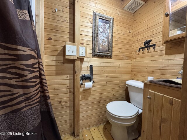 661 Blue Bird Rd, Falls Of Rough, KY 40119 - bathroom with toilet, wooden walls, and wood finished floors