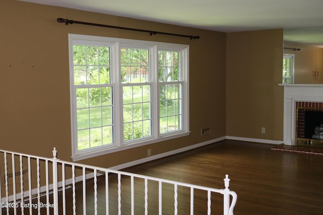 502 Hill Ridge Rd, Louisville, KY 40214 - unfurnished living room with wood finished floors, plenty of natural light, and a brick fireplace