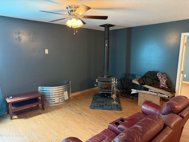 775 Constantine Vertrees Rd, Garfield, KY 40140 - living area with wood finished floors, ceiling fan, a wood stove, and a textured ceiling