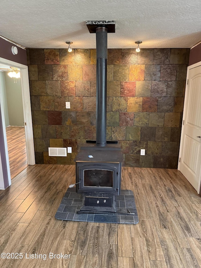 775 Constantine Vertrees Rd, Garfield, KY 40140 - detailed view of a wood stove, wood finished floors, a textured ceiling, and a smoke detector