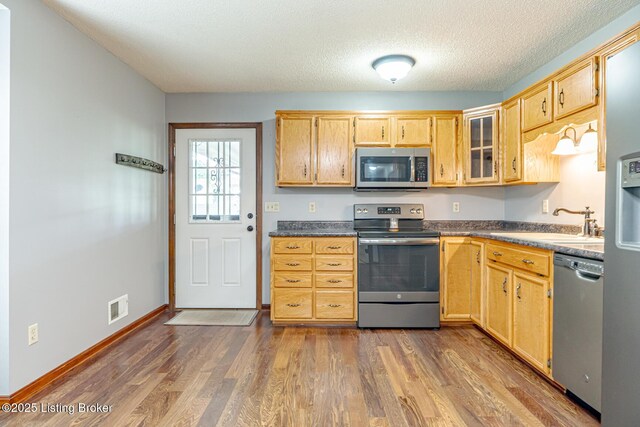 1117 Breezy Way, Bardstown, KY 40004 - kitchen with appliances with stainless steel finishes, dark wood-style flooring, dark countertops, light brown cabinetry, and a textured ceiling