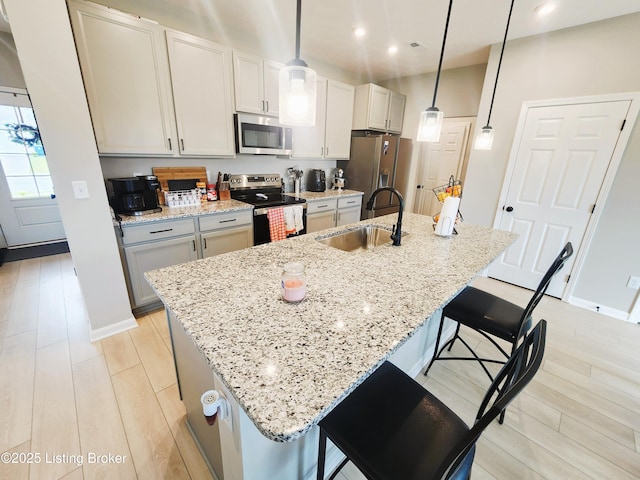 309 Knowledge Point Path, Shelbyville, KY 40065 - kitchen with stainless steel appliances, a kitchen bar, a kitchen island with sink, recessed lighting, and light stone countertops