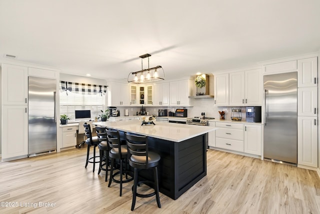 1717 Stricker Rd, Memphis, IN 47143 - kitchen featuring stainless steel appliances, white cabinetry, light countertops, a kitchen breakfast bar, and light wood-style floors