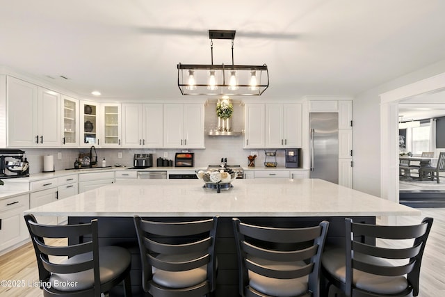 1717 Stricker Rd, Memphis, IN 47143 - kitchen with high quality appliances, a sink, ventilation hood, backsplash, and light wood-style floors
