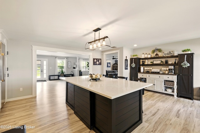 1717 Stricker Rd, Memphis, IN 47143 - kitchen with open shelves, light wood-type flooring, a kitchen island, pendant lighting, and light countertops