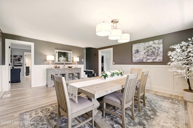 1717 Stricker Rd, Memphis, IN 47143 - dining area featuring a wainscoted wall, a decorative wall, light wood finished floors, and stairway