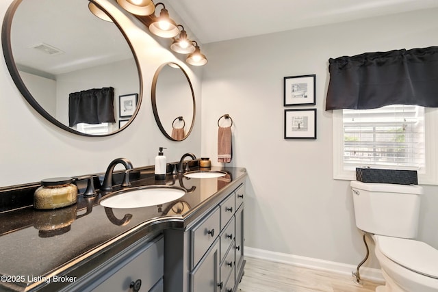 1717 Stricker Rd, Memphis, IN 47143 - full bath with double vanity, toilet, baseboards, and wood finished floors