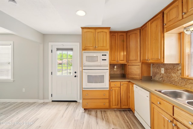 1717 Stricker Rd, Memphis, IN 47143 - kitchen with white appliances, light wood-style floors, backsplash, light countertops, and a sink