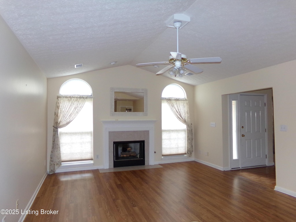 9509 Antioch Dr, Louisville, KY 40291 - unfurnished living room with wood finished floors, ceiling fan, plenty of natural light, a fireplace with flush hearth, and lofted ceiling