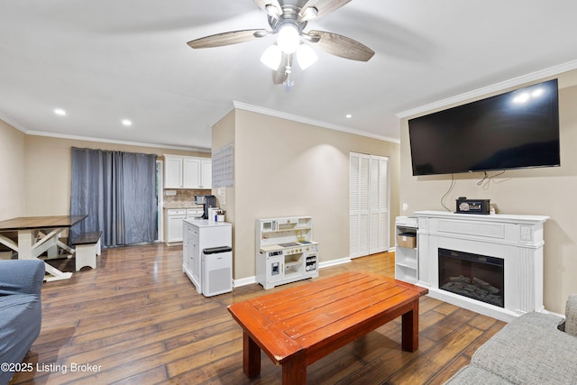 90 Shellys Trce, Brandenburg, KY 40108 - living area featuring crown molding, a ceiling fan, dark wood-style flooring, recessed lighting, and a glass covered fireplace