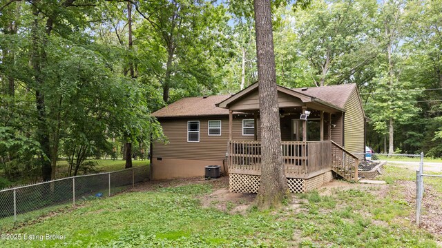 90 Shellys Trce, Brandenburg, KY 40108 - rear view of property featuring a fenced backyard, a deck, view of wooded area, roof with shingles, and cooling unit