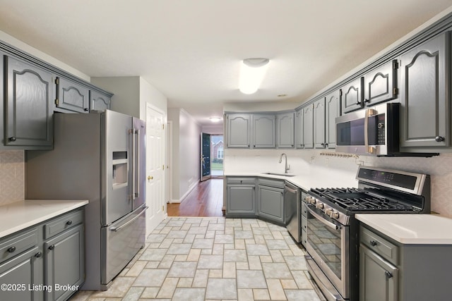 5121 Oaklawn Park Dr, Louisville, KY 40299 - kitchen featuring stainless steel appliances, a sink, tasteful backsplash, and gray cabinetry