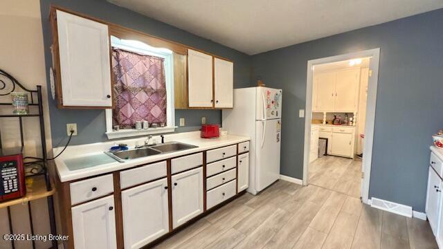 187 Glenn Rd, Leitchfield, KY 42754 - kitchen featuring a sink, freestanding refrigerator, light countertops, light wood-type flooring, and baseboards