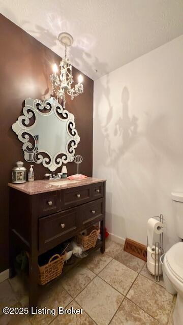 187 Glenn Rd, Leitchfield, KY 42754 - half bathroom featuring toilet, a chandelier, baseboards, tile patterned flooring, and vanity