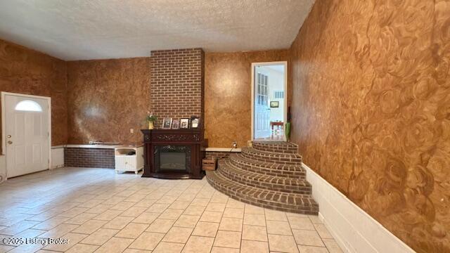187 Glenn Rd, Leitchfield, KY 42754 - unfurnished living room featuring a textured ceiling and a wainscoted wall