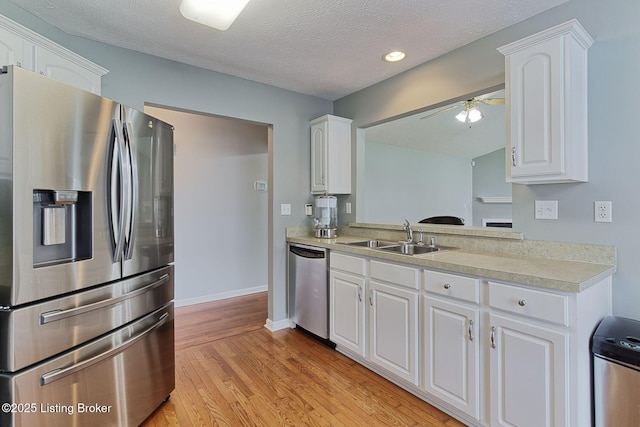 10540 Monticello Forest Cir, Louisville, KY 40299 - kitchen featuring stainless steel appliances, a sink, light countertops, light wood-type flooring, and white cabinetry