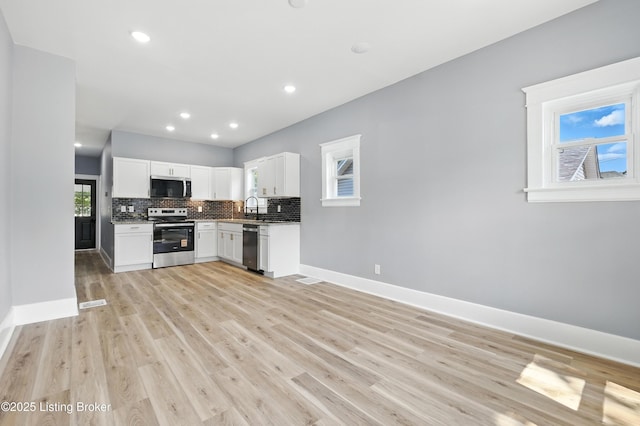 220 N 39th St, Louisville, KY 40212 - kitchen with stainless steel appliances, tasteful backsplash, white cabinetry, light wood finished floors, and recessed lighting