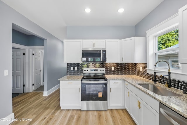 220 N 39th St, Louisville, KY 40212 - kitchen with appliances with stainless steel finishes, white cabinetry, tasteful backsplash, light wood-style flooring, and recessed lighting