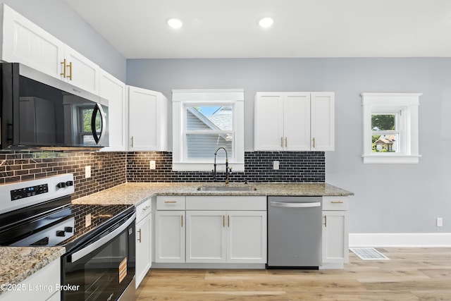 220 N 39th St, Louisville, KY 40212 - kitchen with stainless steel appliances, white cabinets, decorative backsplash, light stone counters, and recessed lighting