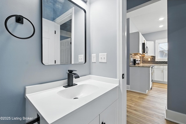220 N 39th St, Louisville, KY 40212 - bathroom with wood finished floors, backsplash, vanity, and recessed lighting
