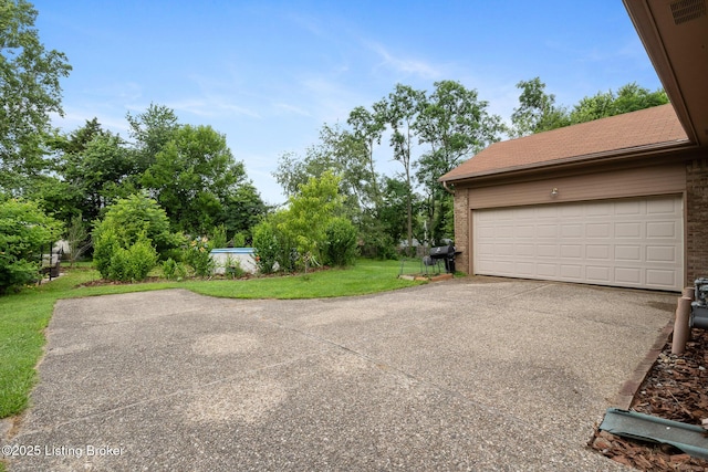 6800 Beard Ct, Louisville, KY 40228 - garage featuring driveway and view of scattered trees