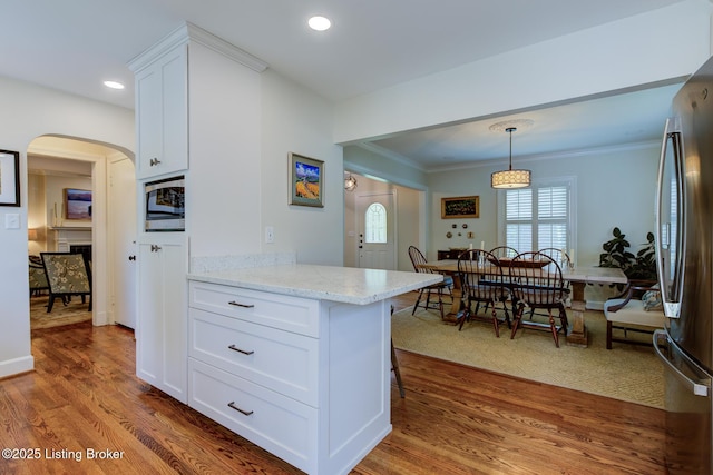 2417 Meadow Rd, Seneca Gardens, KY 40205 - kitchen with appliances with stainless steel finishes, wood finished floors, ornamental molding, white cabinets, and light stone countertops