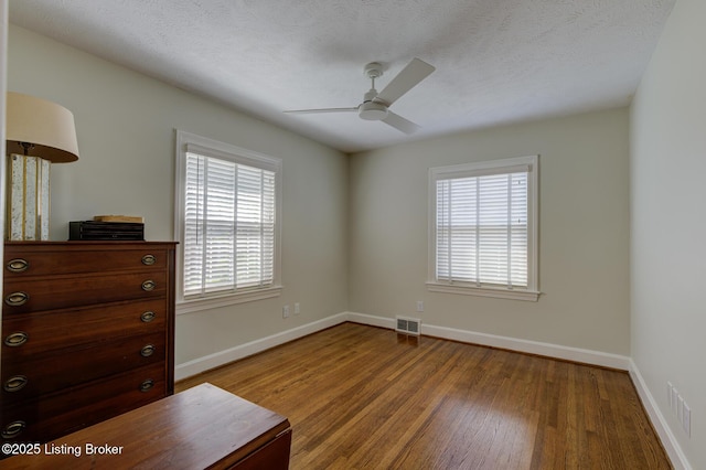 2417 Meadow Rd, Seneca Gardens, KY 40205 - bedroom featuring multiple windows, wood finished floors, baseboards, and a textured ceiling