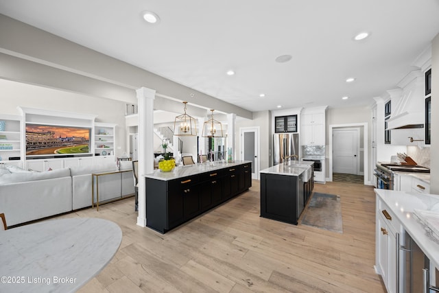 5404 River Creek Ct, Prospect, KY 40059 - kitchen featuring dark cabinetry, a large island with sink, open floor plan, stainless steel appliances, and custom range hood