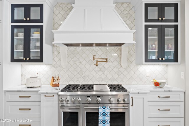 5404 River Creek Ct, Prospect, KY 40059 - kitchen featuring range with two ovens, custom range hood, glass insert cabinets, white cabinetry, and tasteful backsplash