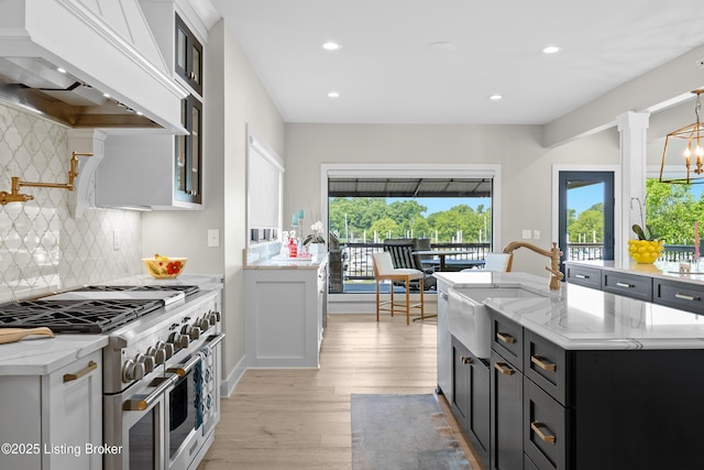 5404 River Creek Ct, Prospect, KY 40059 - kitchen with range with two ovens, premium range hood, dark cabinets, healthy amount of natural light, and recessed lighting