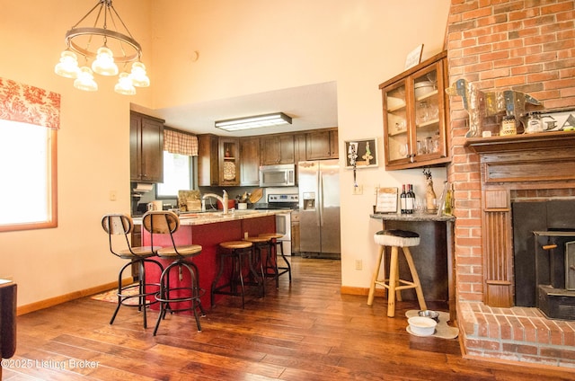 52 Lakeshore Cir, Leitchfield, KY 42754 - kitchen featuring appliances with stainless steel finishes, a kitchen bar, wood finished floors, glass insert cabinets, and a high ceiling