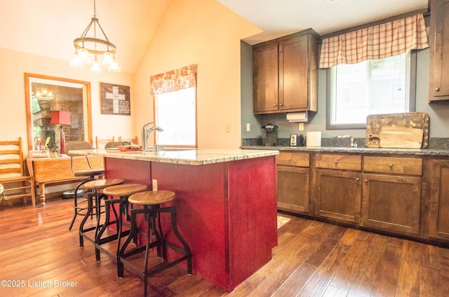 52 Lakeshore Cir, Leitchfield, KY 42754 - kitchen featuring dark wood-style floors, a breakfast bar, pendant lighting, a kitchen island with sink, and light stone countertops