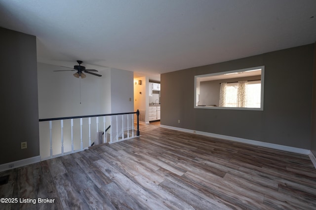 7215 Applegate Ln, Louisville, KY 40228 - spare room featuring wood finished floors, a ceiling fan, baseboards, and a sink