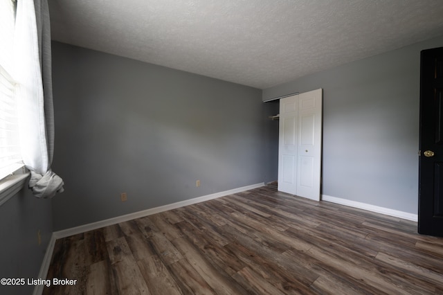 7215 Applegate Ln, Louisville, KY 40228 - unfurnished bedroom featuring a textured ceiling, dark wood finished floors, baseboards, and a closet