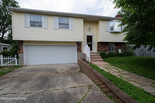 7215 Applegate Ln, Louisville, KY 40228 - split foyer home with brick siding, a garage, and concrete driveway