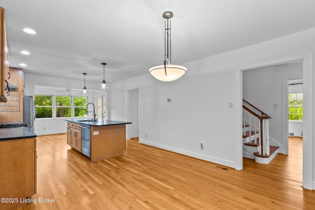 213 Barberry Ln, Lexington, KY 40503 - kitchen featuring stainless steel appliances, a sink, dark countertops, light wood-style floors, and an island with sink