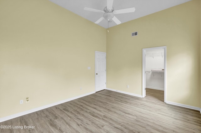 8405 Adams Run Rd, Louisville, KY 40228 - unfurnished bedroom with a towering ceiling, baseboards, wood finished floors, a closet, and a walk in closet