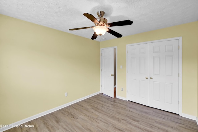 8405 Adams Run Rd, Louisville, KY 40228 - unfurnished bedroom with wood finished floors, baseboards, a closet, a textured ceiling, and a ceiling fan