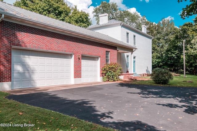 4893 N Preston Way, Shepherdsville, KY 40165 - view of side of property with a chimney, brick siding, driveway, and an attached garage