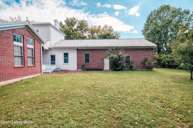4893 N Preston Way, Shepherdsville, KY 40165 - back of house with brick siding, a lawn, metal roof, and a chimney