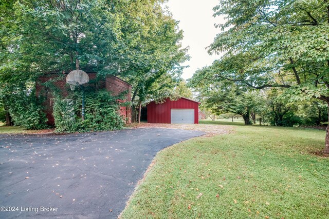 4893 N Preston Way, Shepherdsville, KY 40165 - view of front of home featuring a front lawn, a garage, an outbuilding, and asphalt driveway
