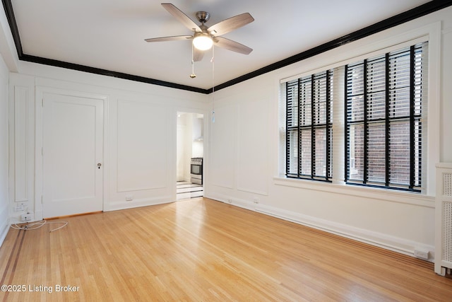 1412 Willow Ave Unit 56, Louisville, KY 40204 - empty room featuring ceiling fan, light wood-style flooring, a decorative wall, and crown molding