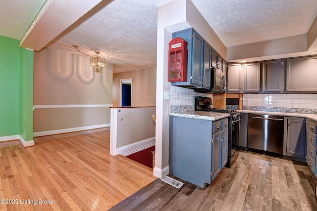 3116 Osprey Rd, Louisville, KY 40213 - kitchen with appliances with stainless steel finishes, light wood finished floors, a chandelier, backsplash, and a textured ceiling