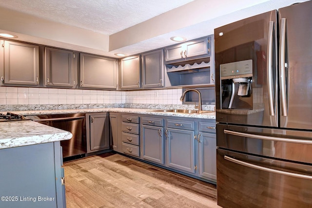 3116 Osprey Rd, Louisville, KY 40213 - kitchen with stainless steel appliances, light wood finished floors, a textured ceiling, tasteful backsplash, and gray cabinetry