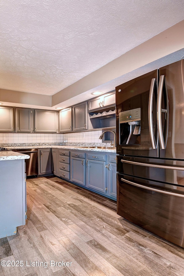 3116 Osprey Rd, Louisville, KY 40213 - kitchen featuring stainless steel appliances, light wood-style floors, a textured ceiling, backsplash, and blue cabinetry