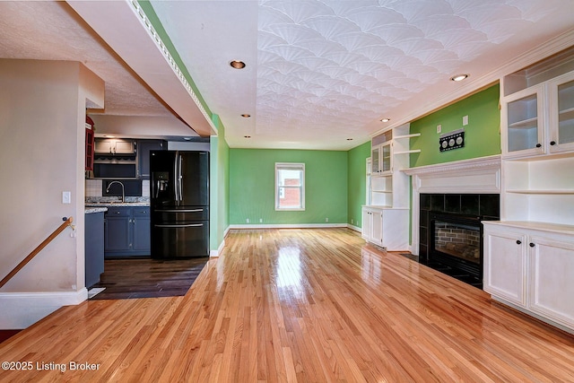 3116 Osprey Rd, Louisville, KY 40213 - unfurnished living room featuring wood finished floors, a tiled fireplace, and recessed lighting
