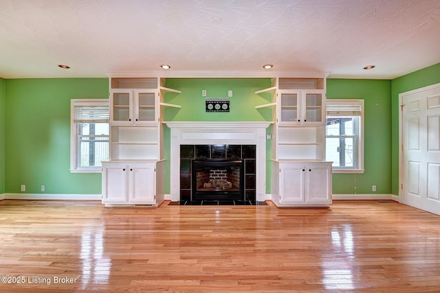 3116 Osprey Rd, Louisville, KY 40213 - unfurnished living room featuring light wood finished floors, healthy amount of natural light, a tile fireplace, and recessed lighting